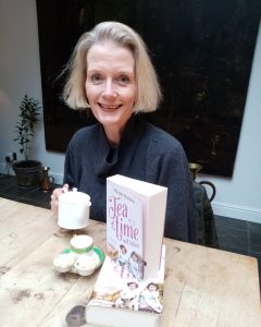 Photo of Author sitting at desk and book