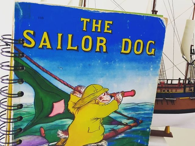Dog cartoon character in a yellow sou-wester looking through a telescope