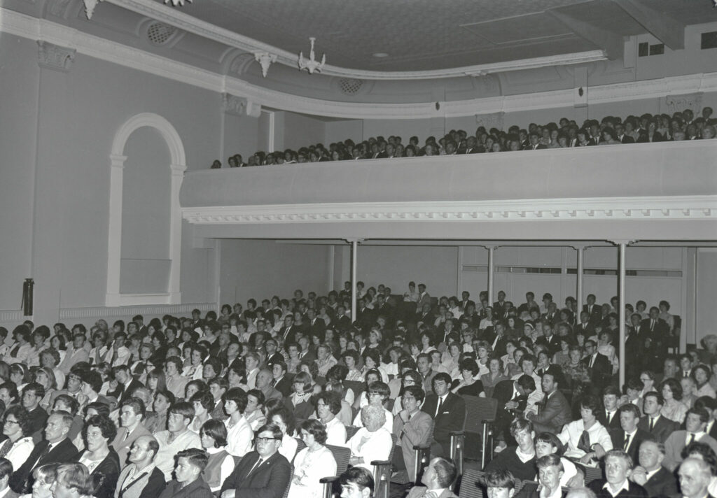 A black and white image of audience watching movies