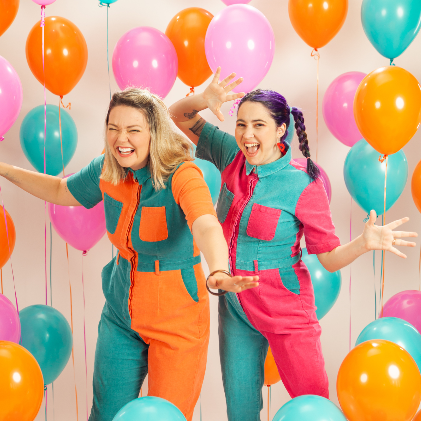 Two women celebrating with colourful balloons at party