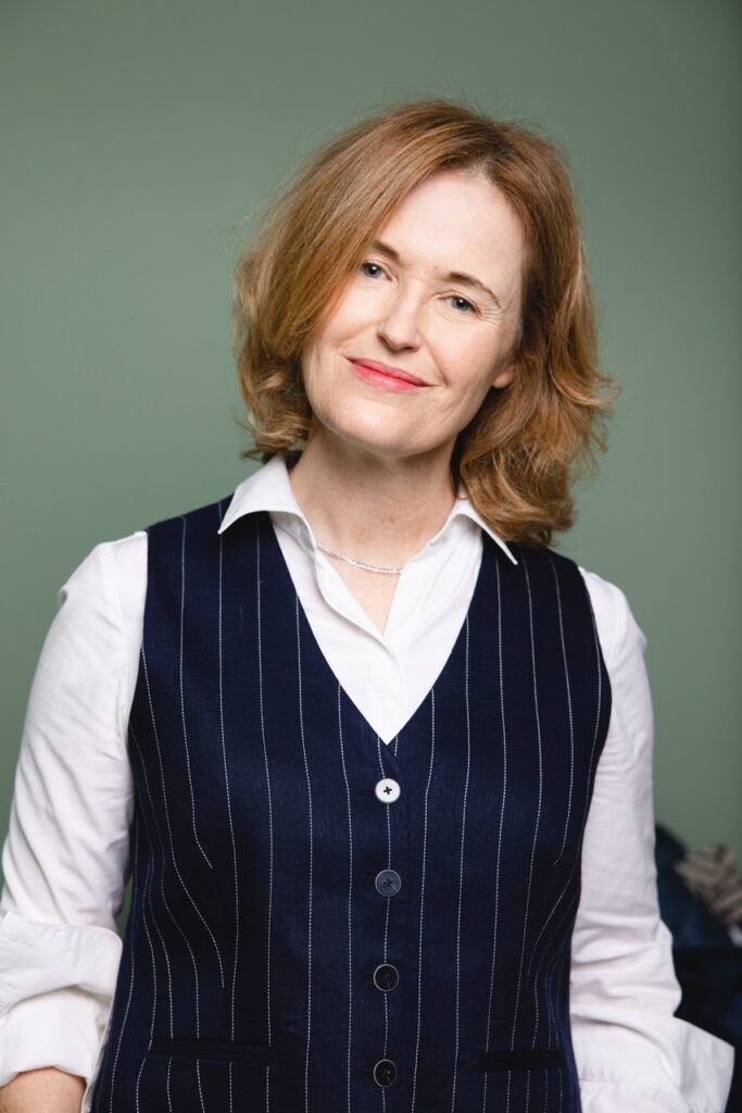 Professional woman in navy pinstripe vest and white shirt
