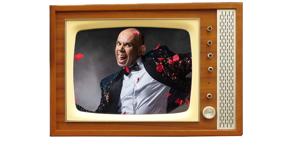 Bald man in sequin jacket screaming on vintage TV screen