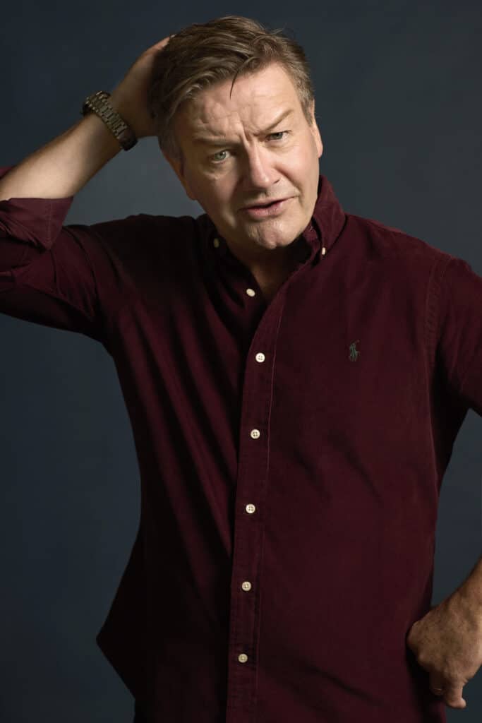 Middle-aged man in burgundy shirt scratching his head