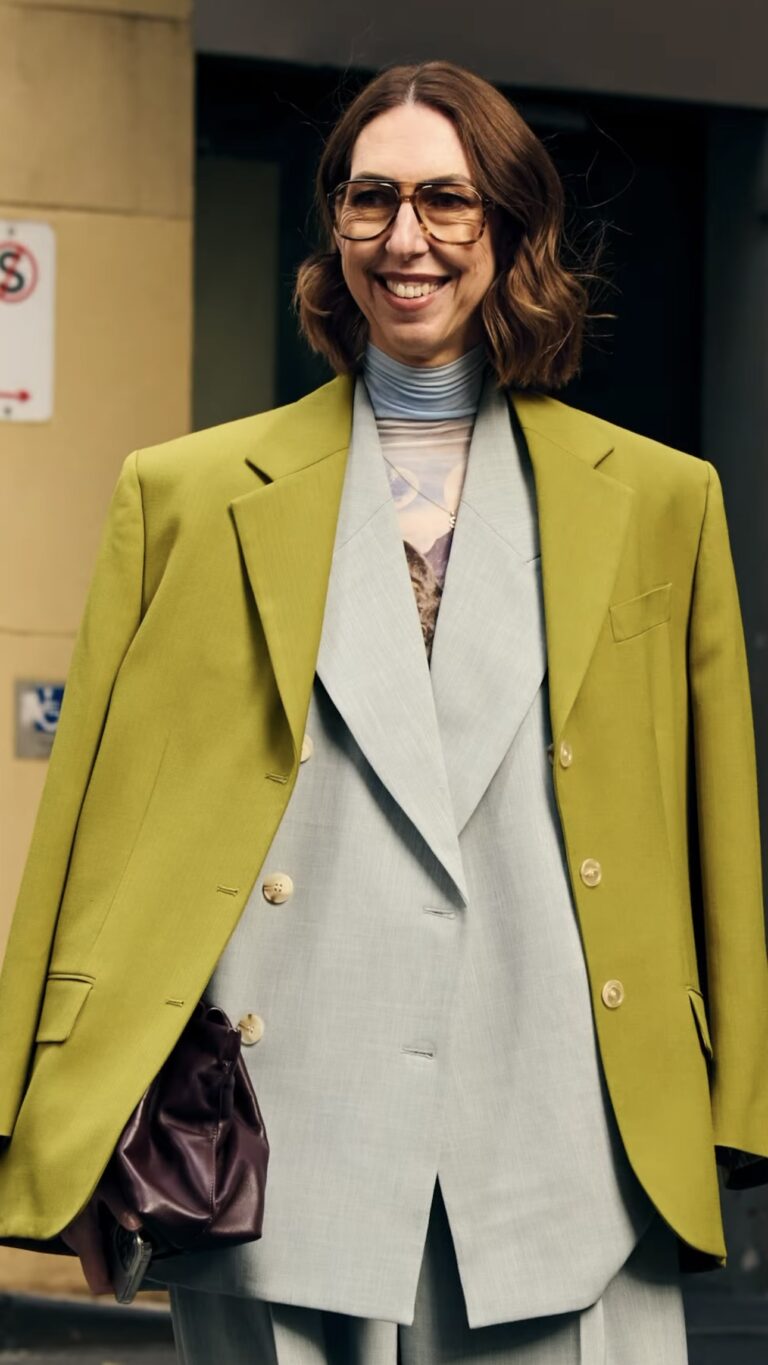Smiling woman in chartreuse blazer and grey suit outdoors