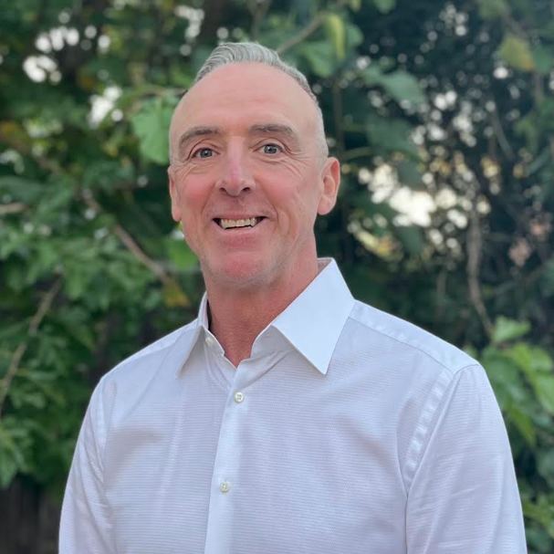 Smiling middle-aged man in white shirt outdoors
