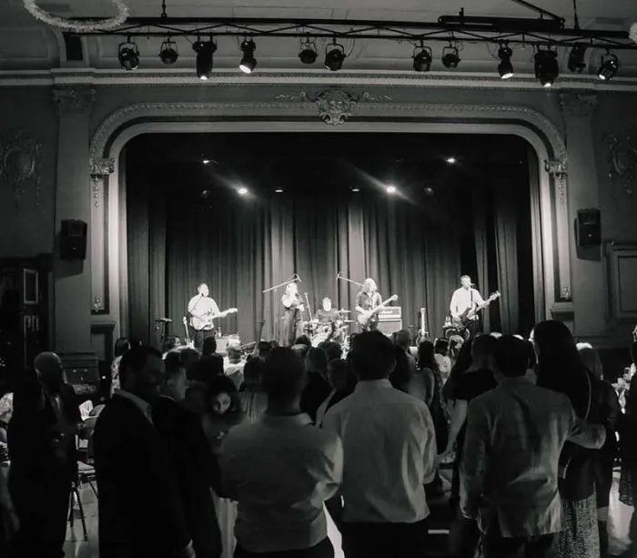 Live band performing on stage at elegant venue with crowd