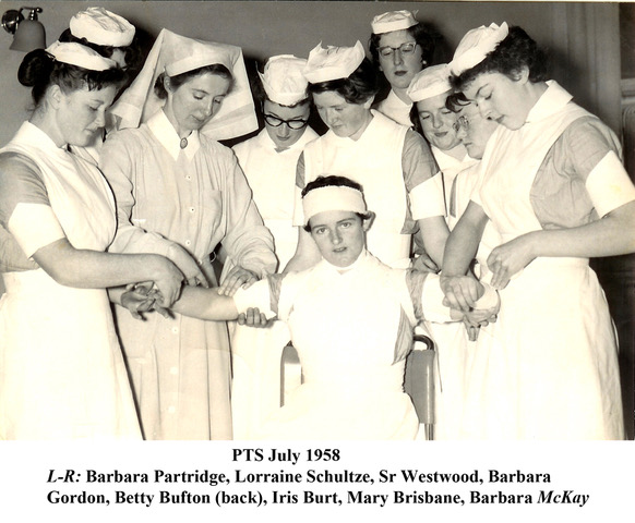 Nurses practising bandaging on a patient in 1958