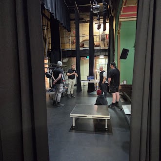 Crew members working backstage in a theatre space