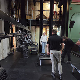 Crew members working backstage in a theatre with rigging equipment
