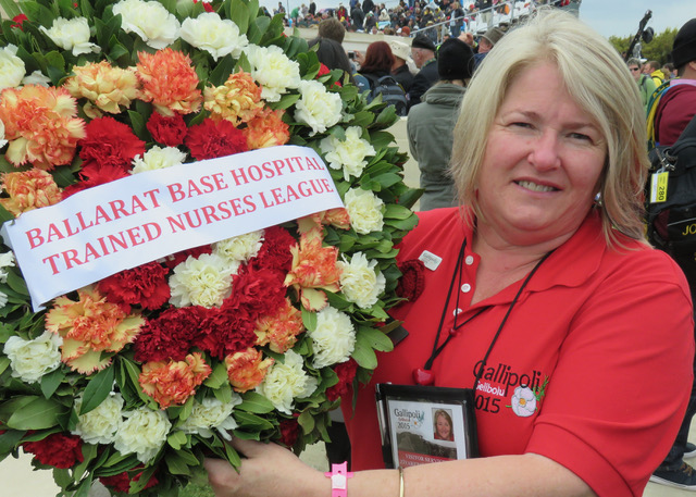 Woman holding floral wreath at Gallipoli commemoration 2015