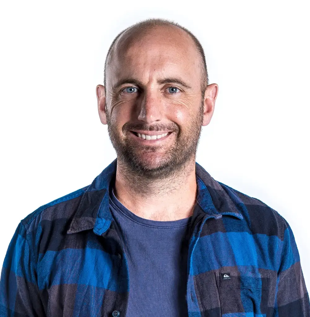 Smiling bald man in blue flannel shirt headshot