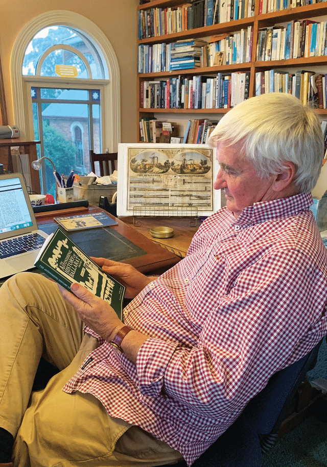 Elderly man reading a book in a home library