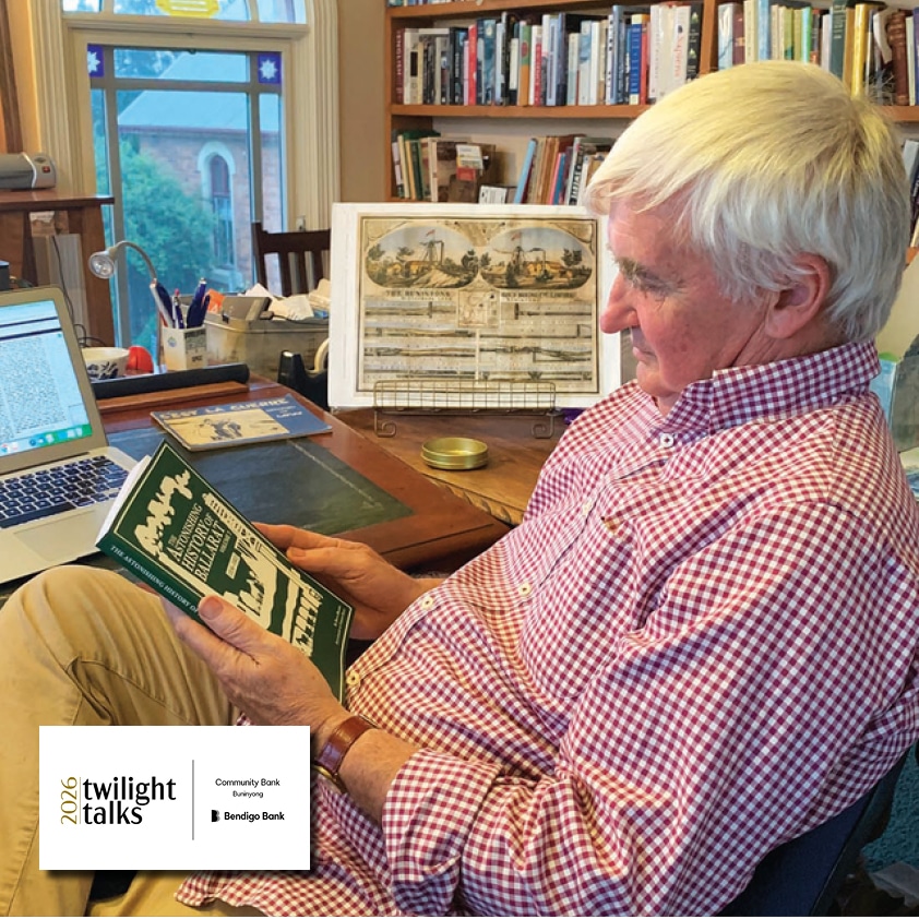 Elderly man reading Ballarat history book in home study