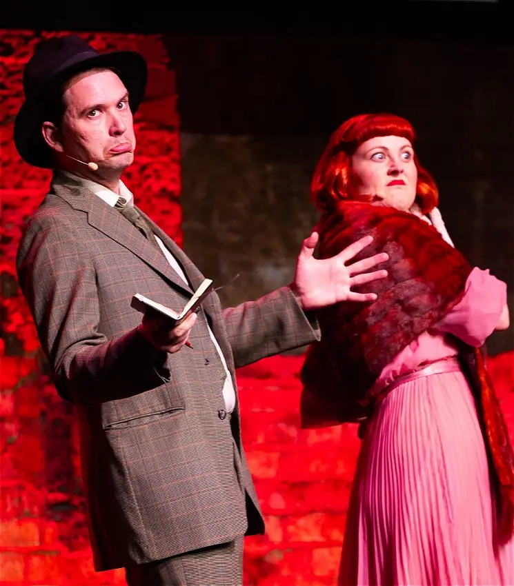 Two actors performing on stage in period costumes