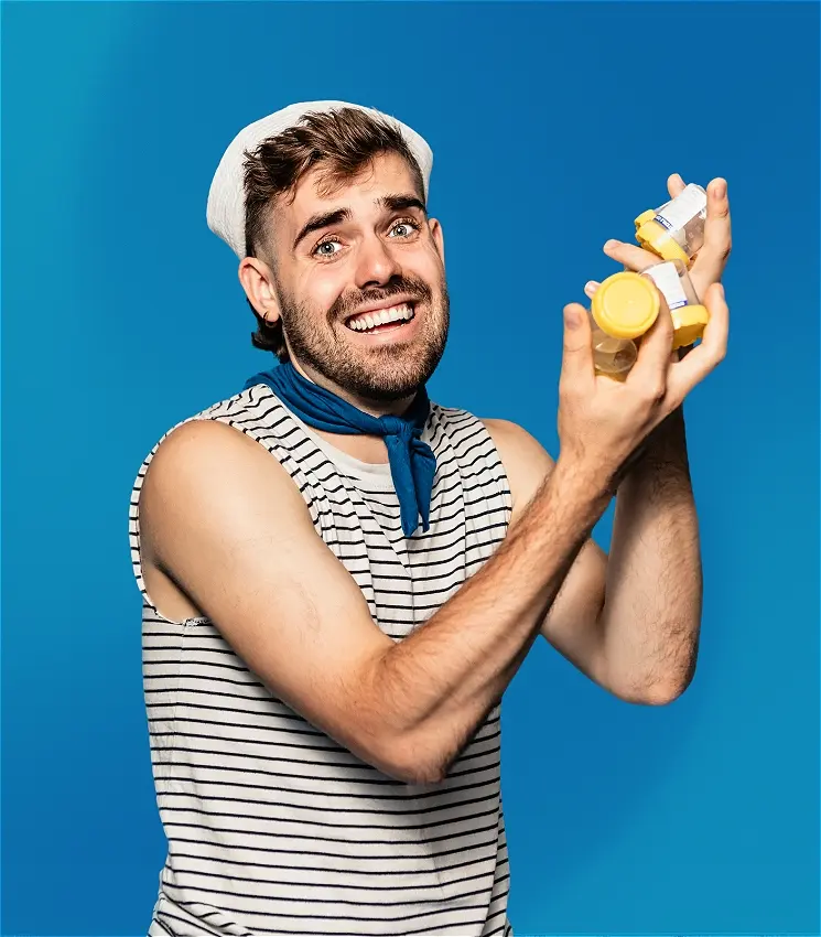 Smiling man in sailor outfit holding small jars