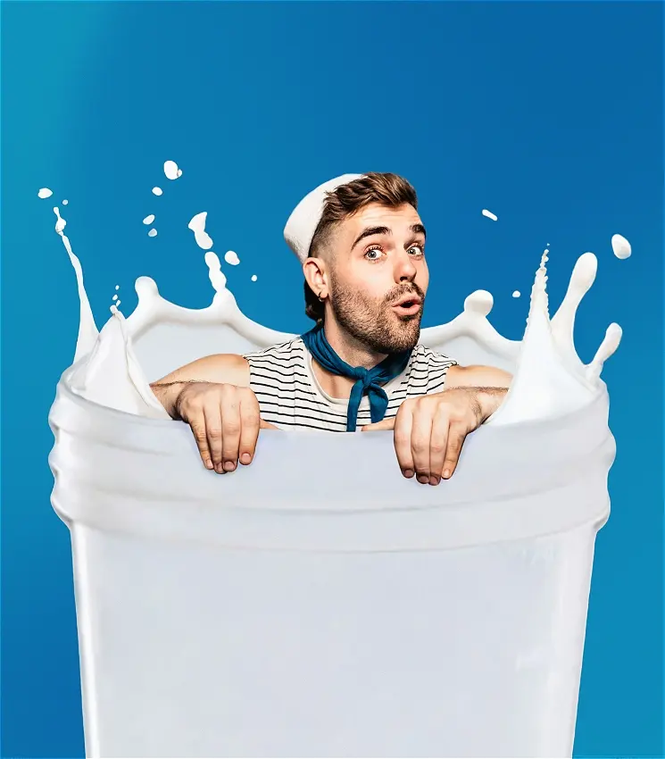 Man emerging from giant splashing glass of milk