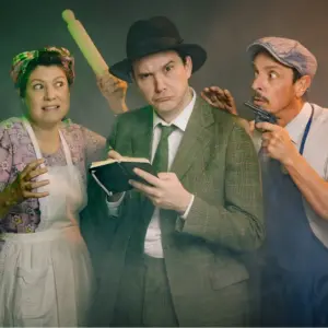 Three theatre actors in costume posing dramatically on stage